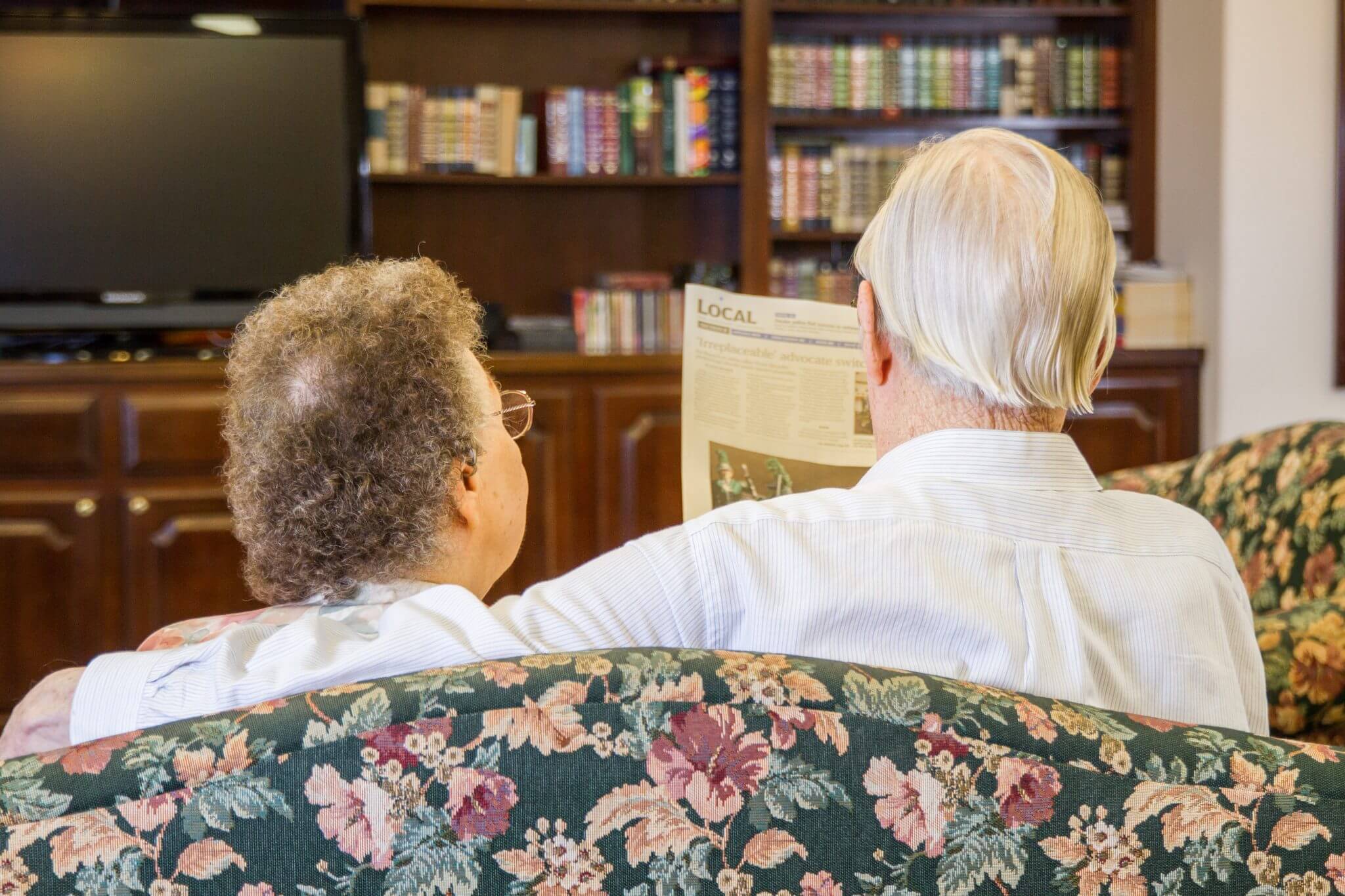 elderly couple reading newspaper