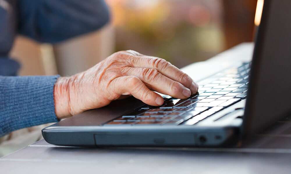 elderly man working on laptop