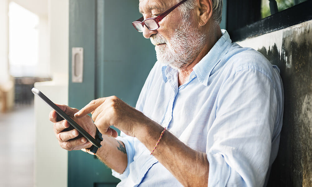 elderly man working on tablet