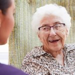 How to Become a CNA as shown by a CNA and a smiling elderly woman