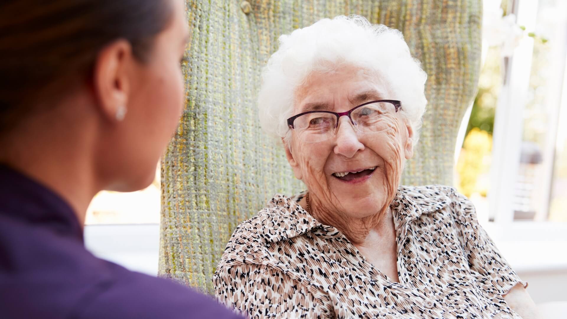 How to Become a CNA as shown by a CNA and a smiling elderly woman