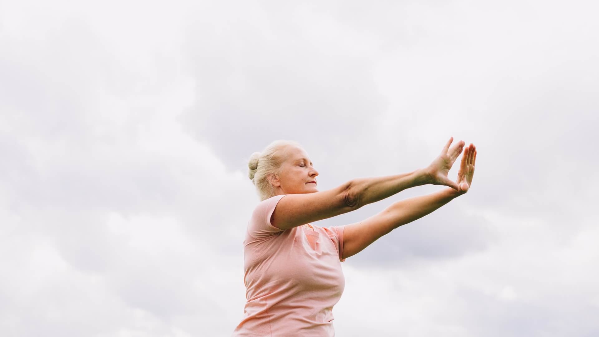 Senior Fitness being practiced outside by an elderly woman.