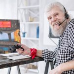 senior man playing video games at home