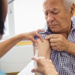 doctor injecting vaccine into senior patient