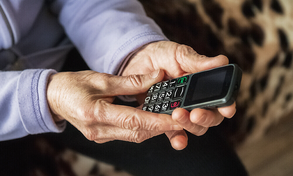 elderly hands holding smart phone technology