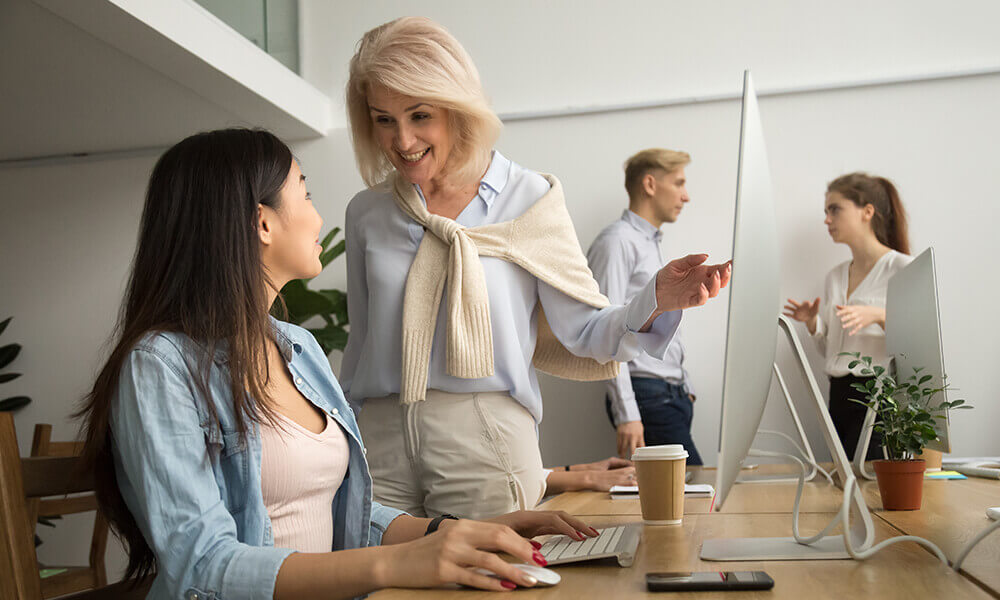 two multi-generational women work together at an office