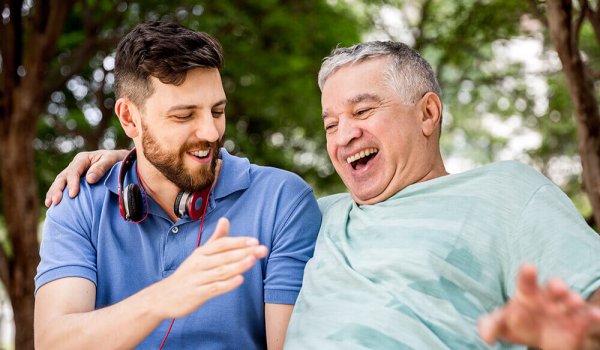 son and father laughing in a park