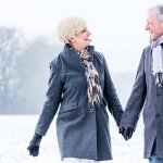 senior couple holding hands while on walk